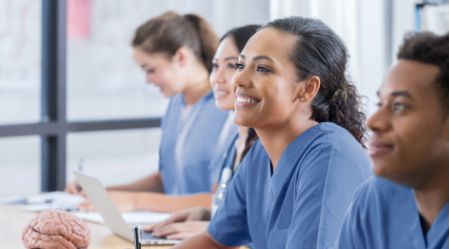Healthcare workers in a classroom setting smiling